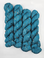 Teal skeins of yarn with donegals on a white background