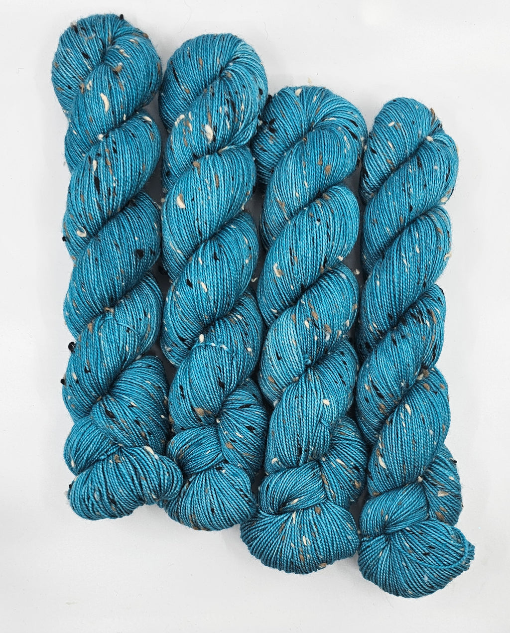 Teal skeins of yarn with donegals on a white background