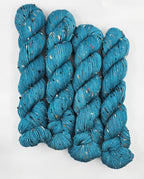 Teal skeins of yarn with donegals on a white background