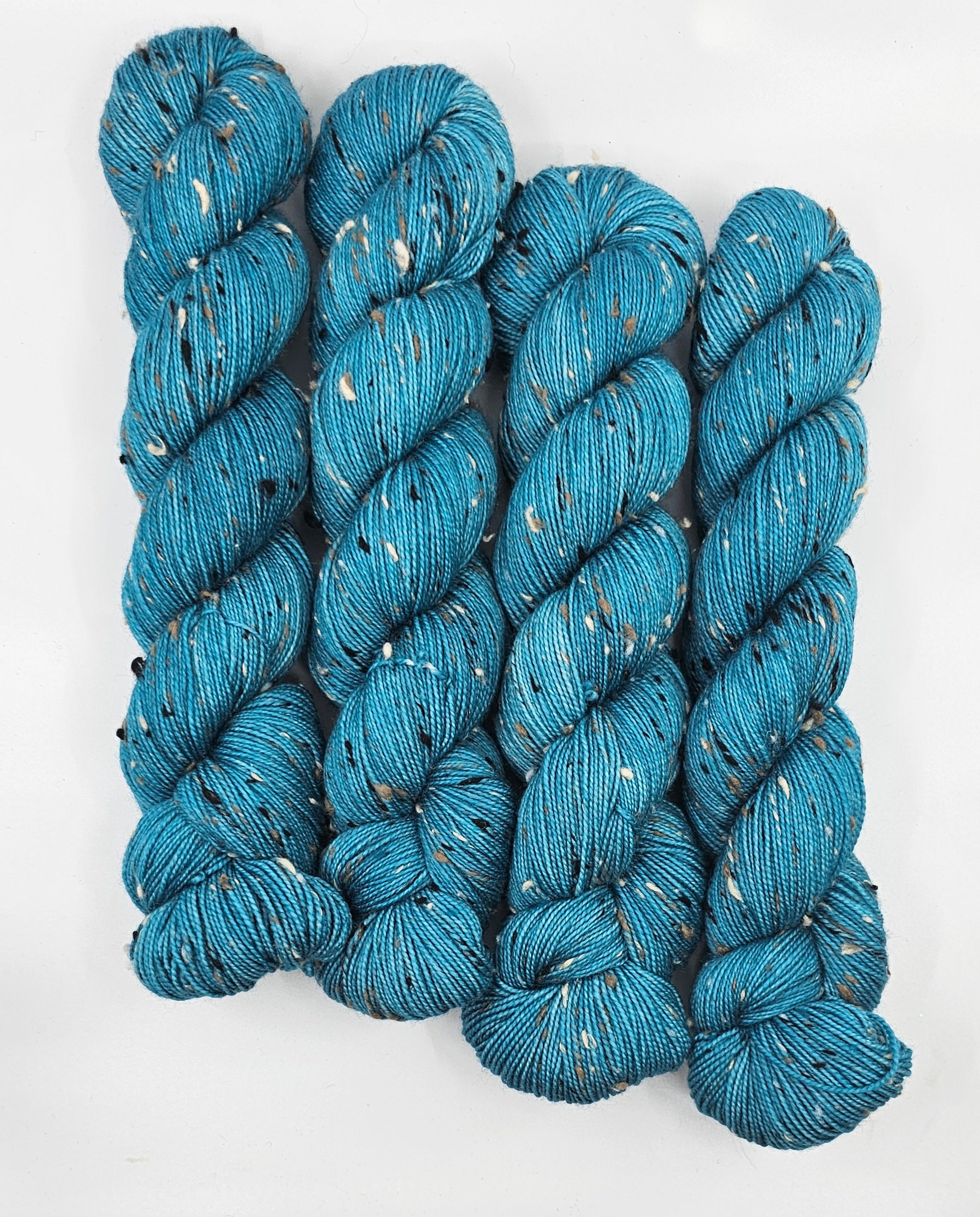 Teal skeins of yarn with donegals on a white background