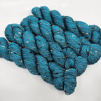 Teal skeins of yarn with donegals on a white background