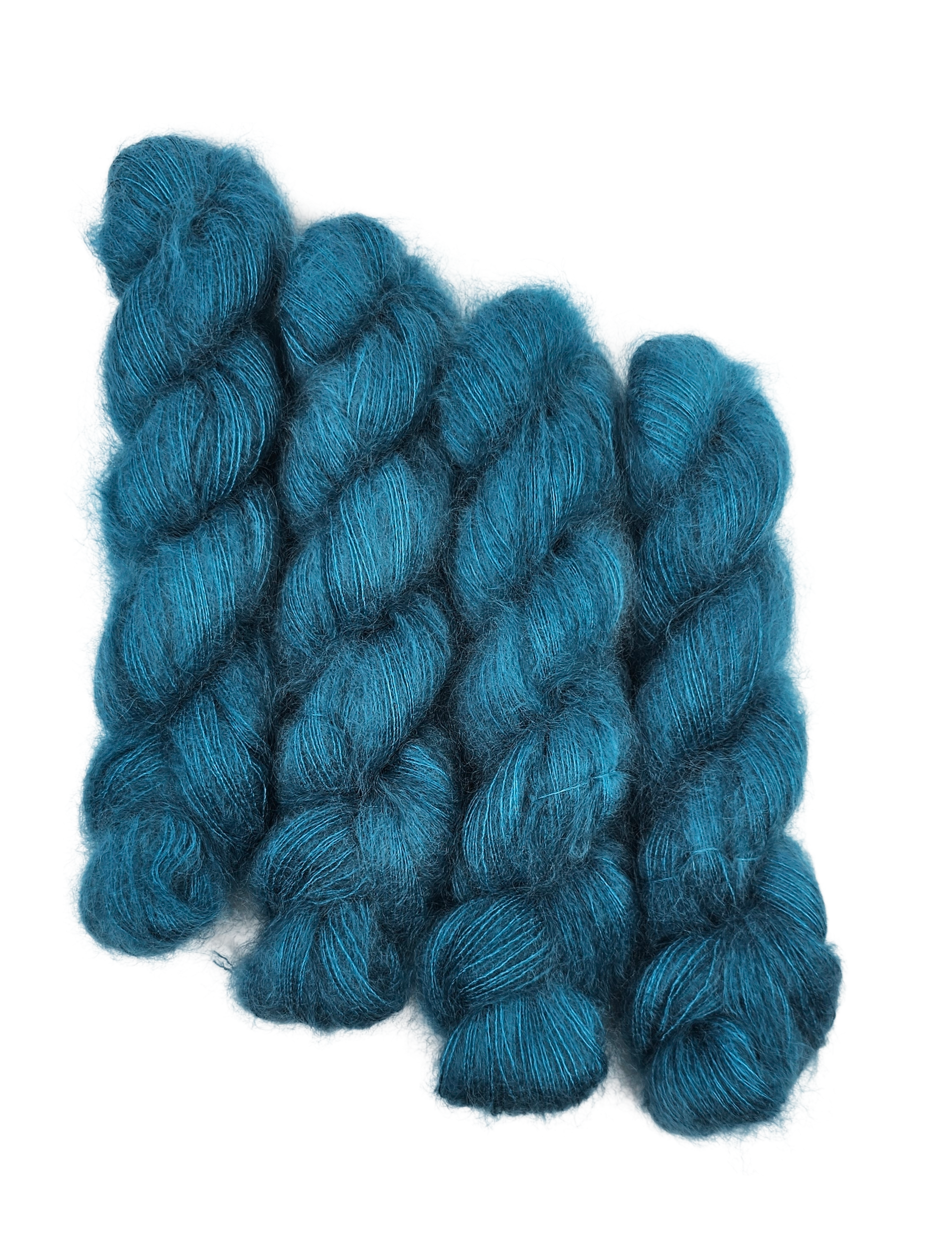 Three skeins of teal/blue mohair yarn on a white background